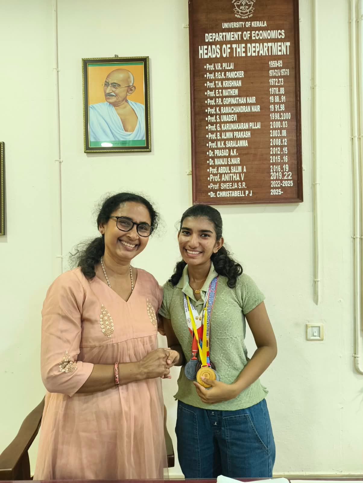 Brahmitha G wearing her medals beside a faculty member at the Department of Economics, University of Kerala