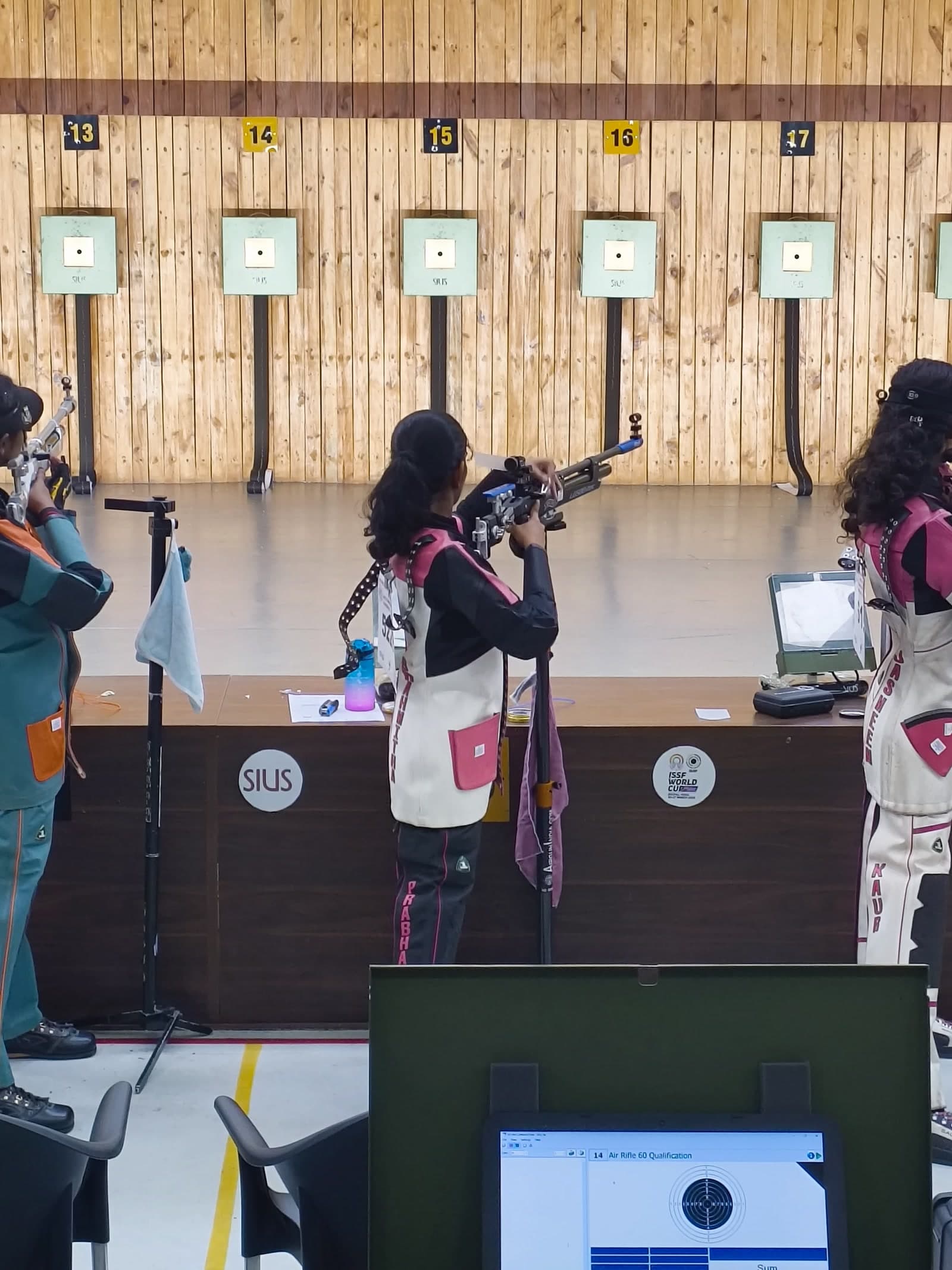 Brahmitha G at her firing point between shots, rifle resting on its stand, electronic targets ahead